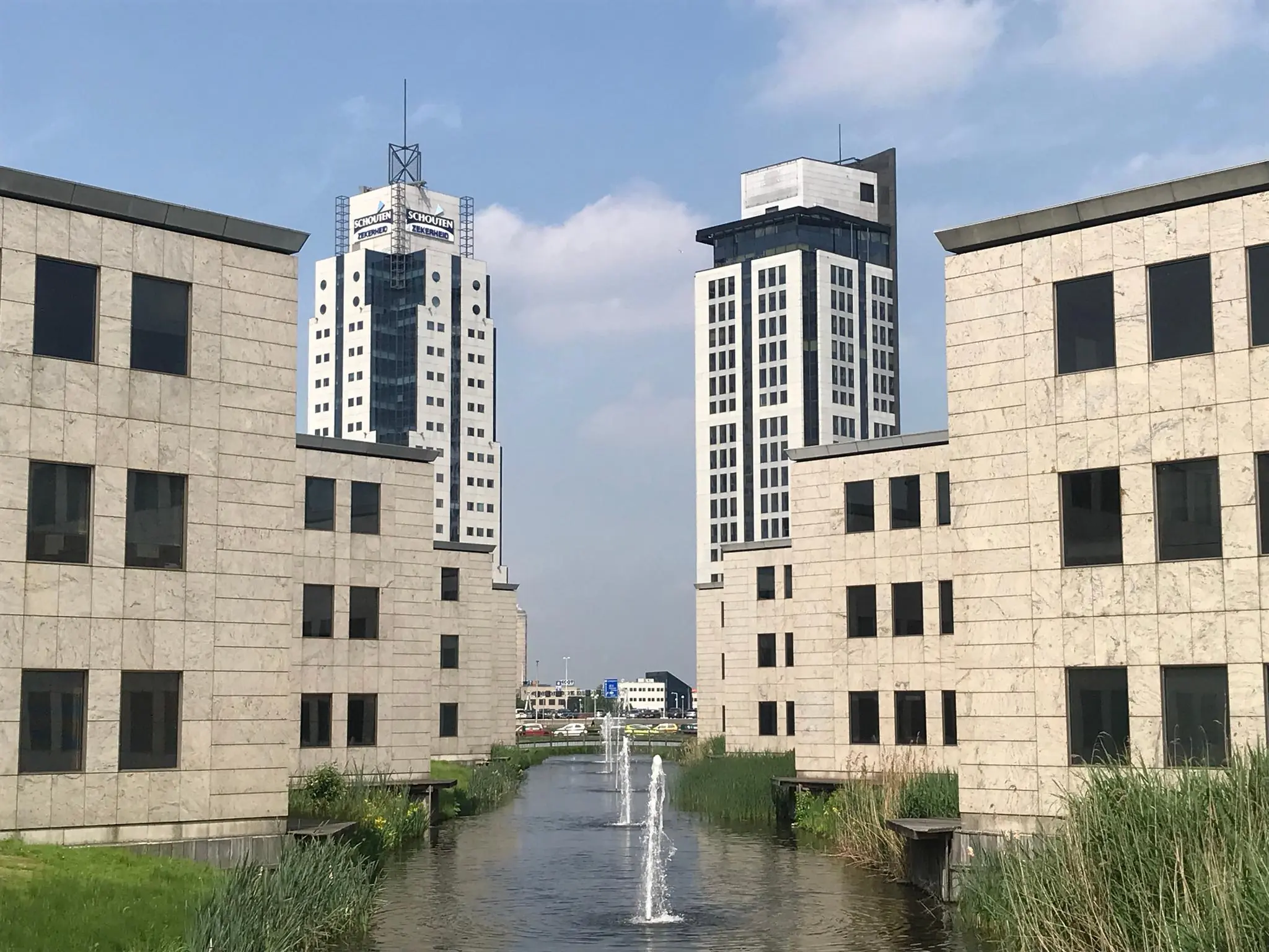 Kantoorgebouwen aan het Rivium Quadrant met een waterpartij en fontein op de voorgrond.